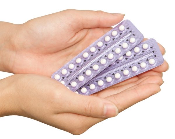 woman holding packs of birth control pills in hands